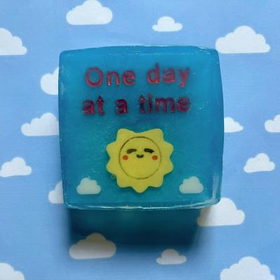 Handmade soap with cute kawaii sun reads “one day at a time”