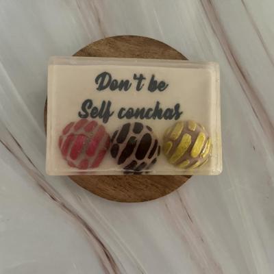 Latina Handmade soap with pan dulce conchas pink yellow and brown that reads “don't be self conchas”